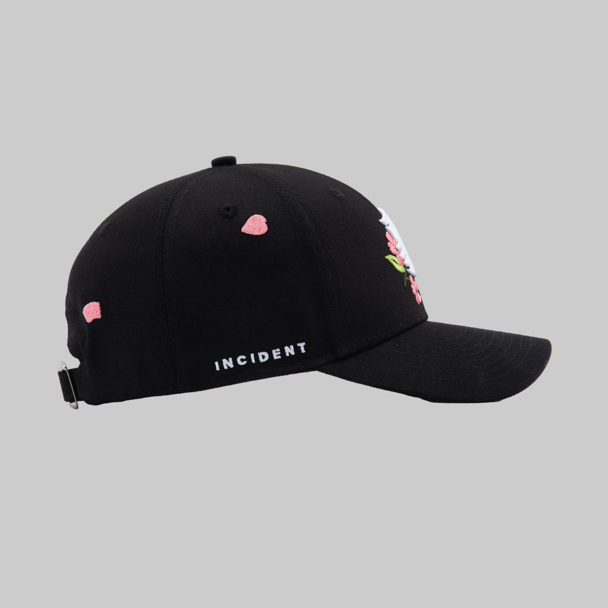 Black cap with pink floral designs and 'INCIDENT' text on a white background