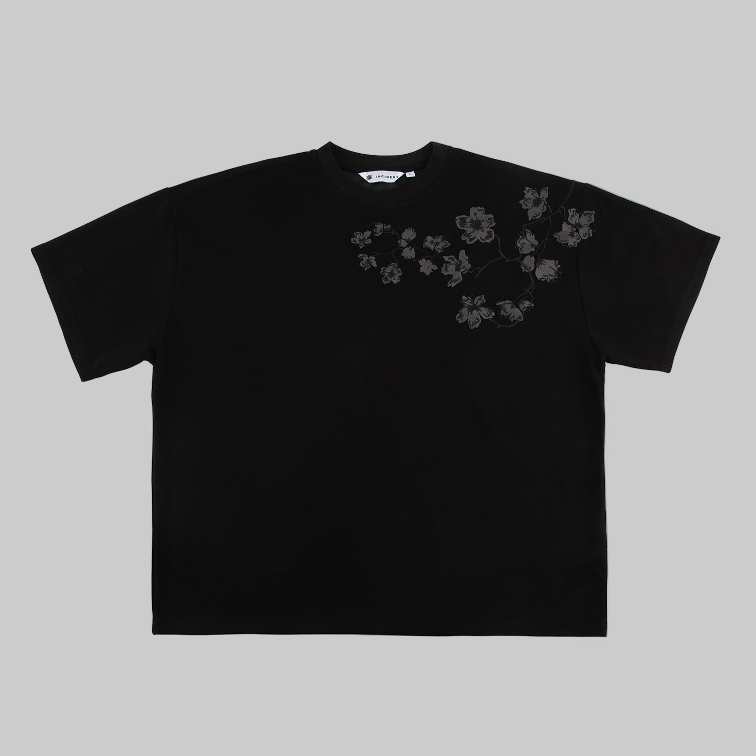 Black t-shirt with embroidered floral design on a white background