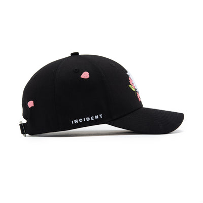 Black cap with pink floral designs and 'INCIDENT' text on a white background