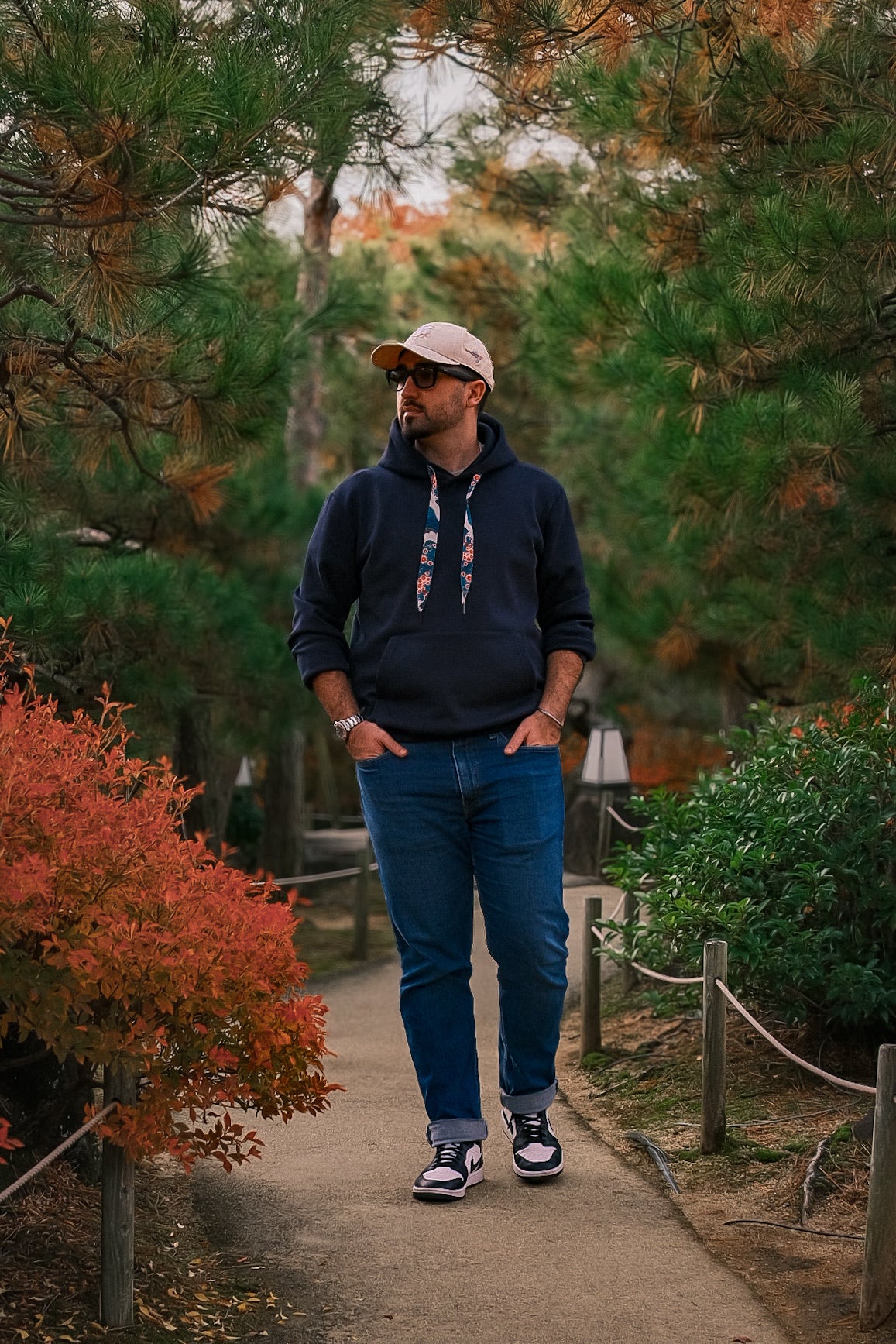 Man walking on a path in a park with trees and bushes around
