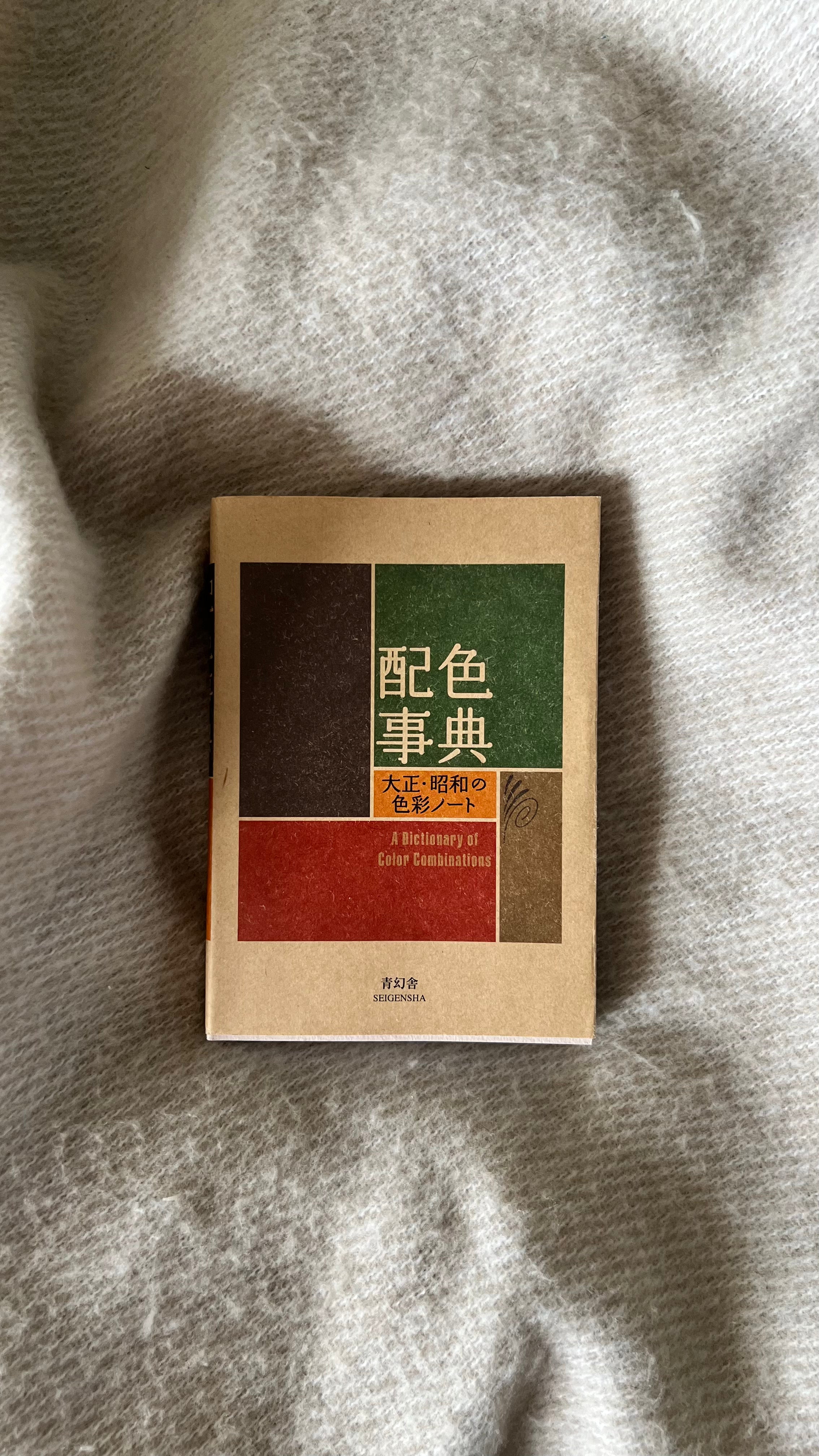 Book with a green and red cover on a textured fabric background